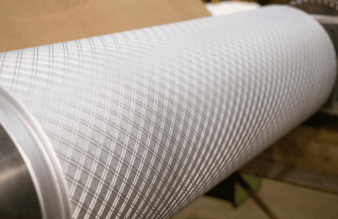 Close-up of precision-engineered industrial embossing roll with surface pattern detail