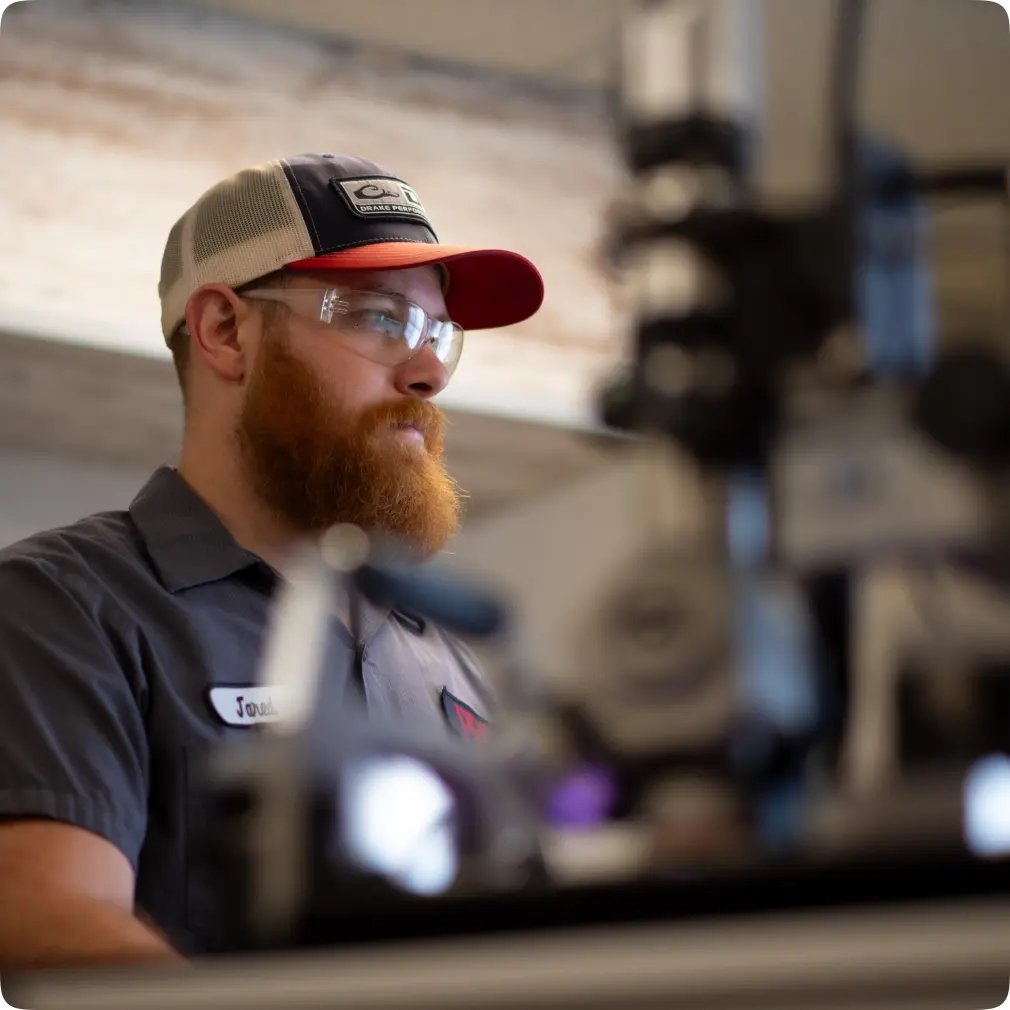 PRS employee wearing safety glasses and a baseball cap with a beard.