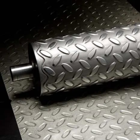 Diamond patterned roller sitting on a diamond pattern piece of steel.