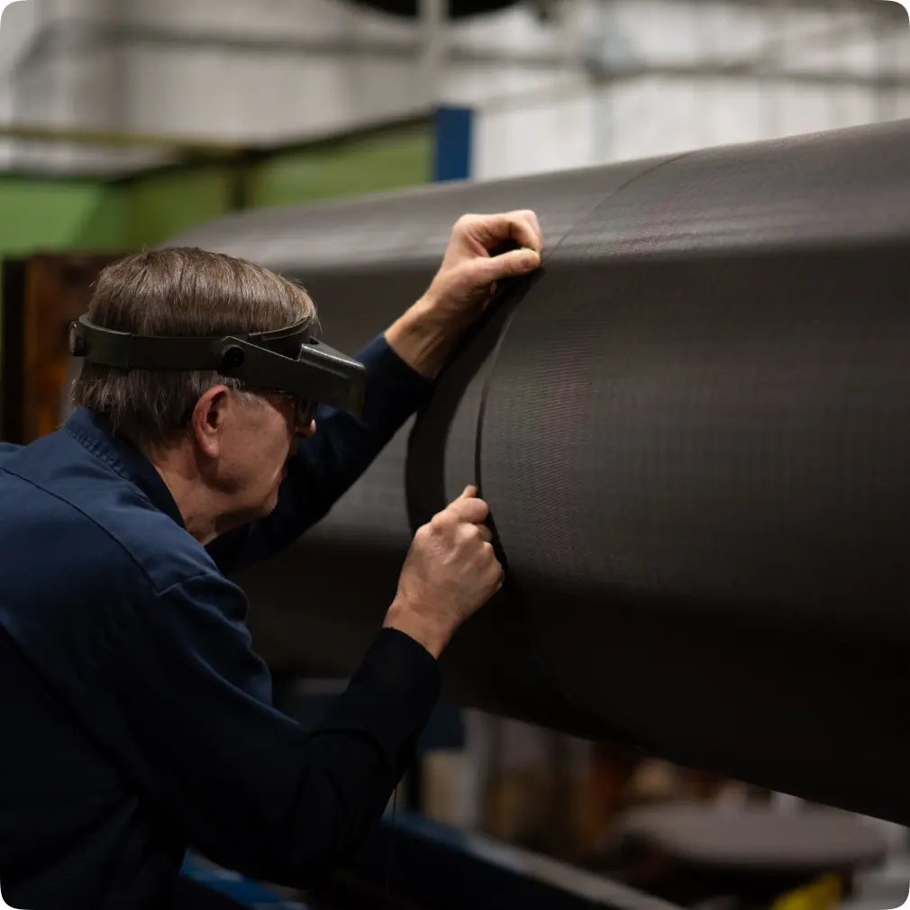 Employee wearing magnification glasses inspecting a roll with a wrap-around tool